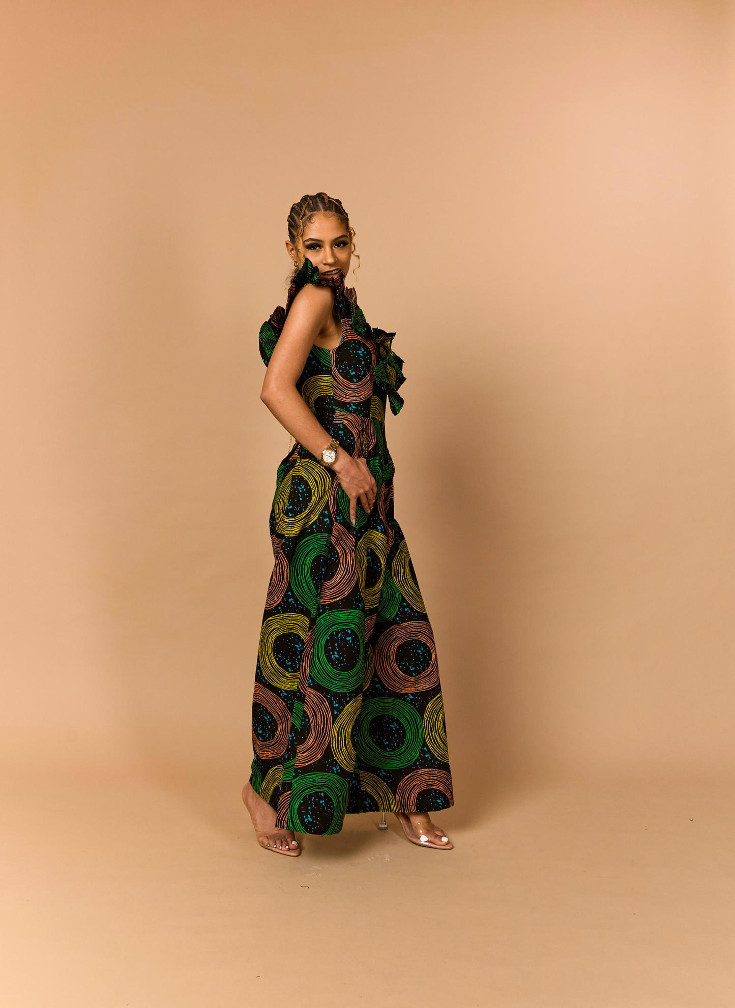 Functional luxury: A green and gold Ankara jumpsuit with deep side pockets and architectural ruffles.