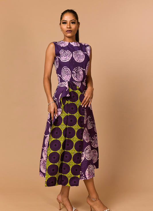 Woman wearing a sleeveless dress with purple and green pattern on a beige background