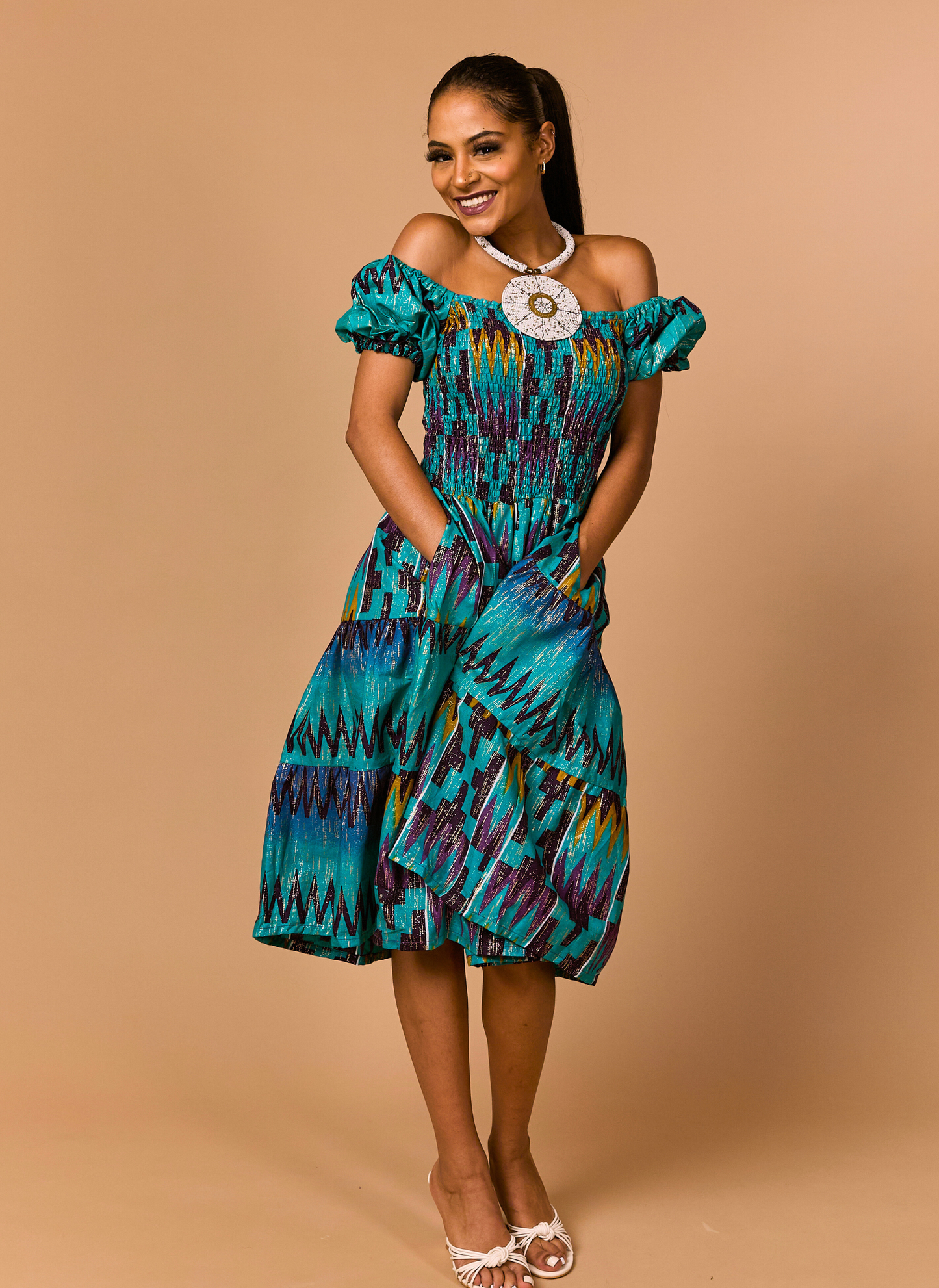 Woman wearing a colorful dress against a beige background