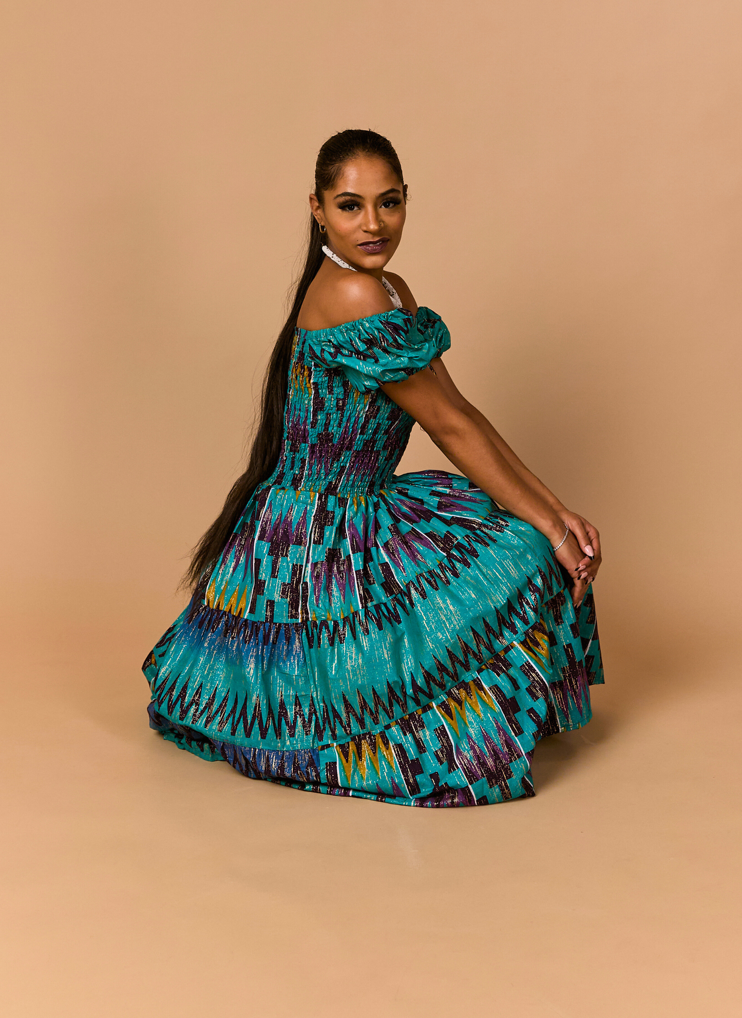 Woman wearing a colorful dress with a pattern on a beige background