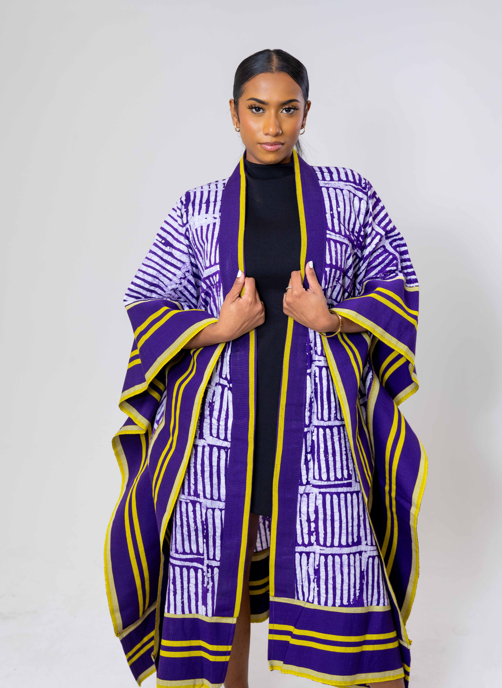 A model wearing a purple and white kimono with geometric patterns and yellow accents.