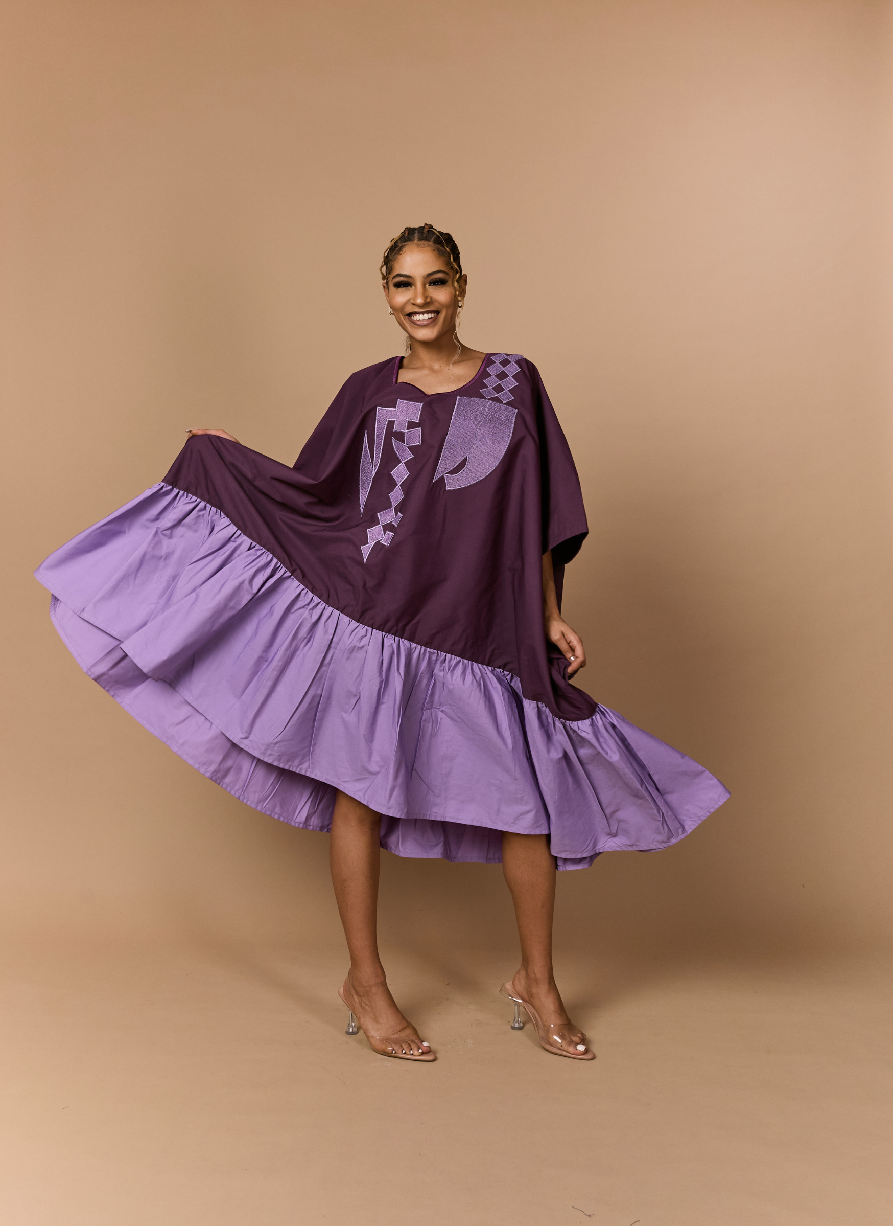 Woman wearing a purple dress with a brown background