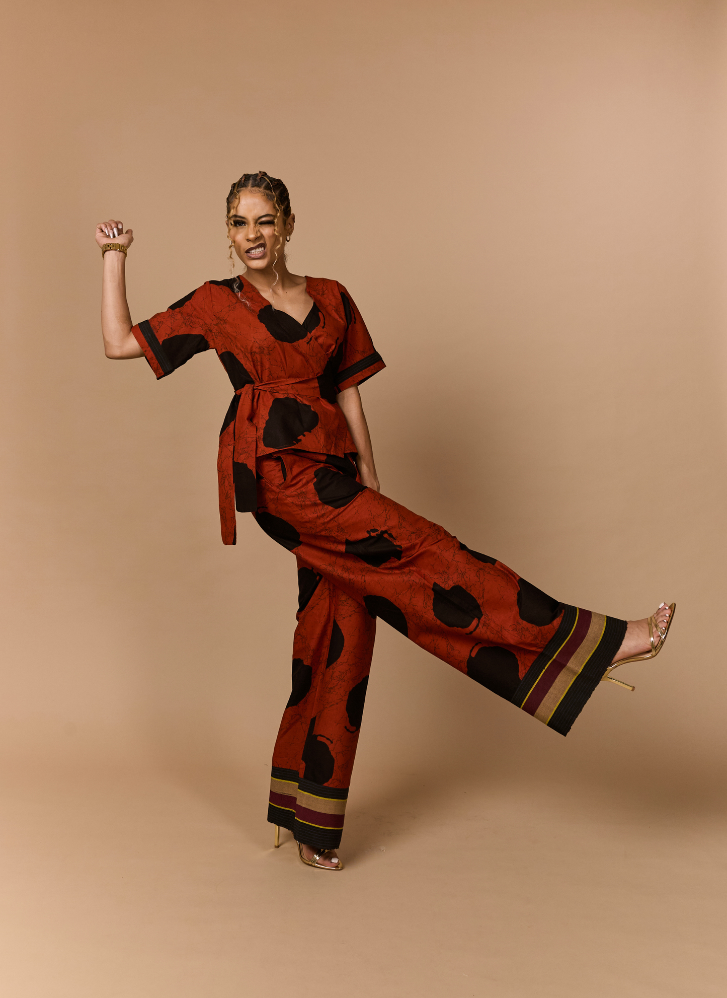 Woman wearing a red and black patterned jumpsuit on a beige background