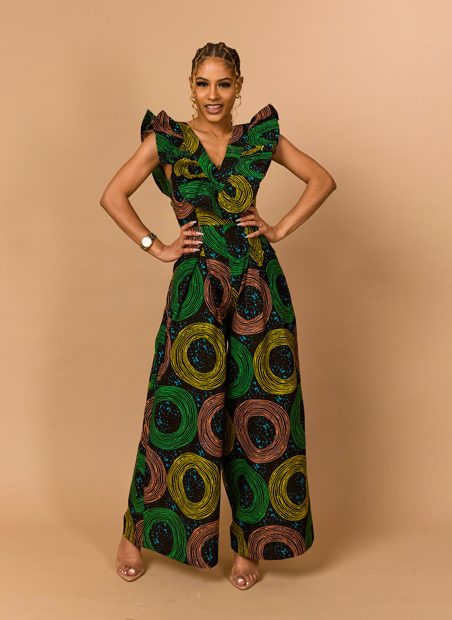 Front view of a green and gold African print jumpsuit with dramatic ruffle sleeves and wide-leg trousers