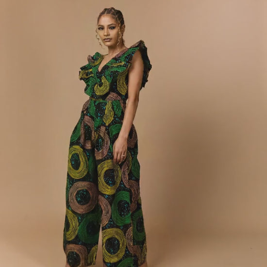 Close-up of premium cotton Ankara fabric on a wide-leg jumpsuit with vibrant green circular patterns.